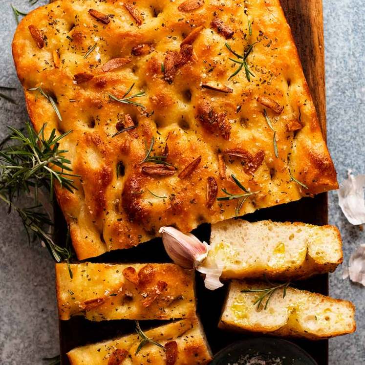 Overhead photo of Rosemary Garlic Focaccia on a wooden board, ready to be served